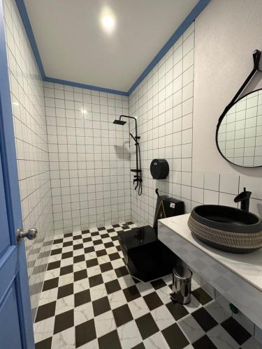 a bathroom with a black and white checkered floor at Sadakham Hotel in Luang Prabang