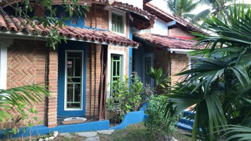 Una casa con una puerta azul a un lado. en Residencial Alto do Arraial, en Arraial d'Ajuda