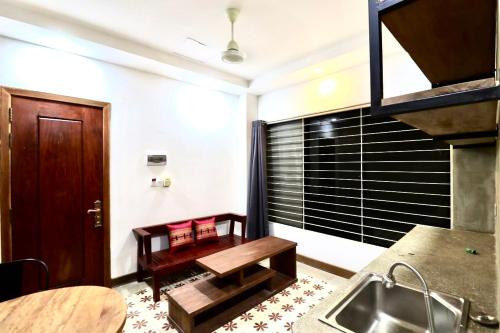 eine Küche mit einem Waschbecken und einem Tisch in einem Zimmer in der Unterkunft Theary apartment in Phumĭ Ta Phŭl