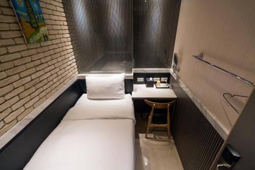 two beds in a small room with a stool at Kenting 157 Boutique Hotel in Kenting