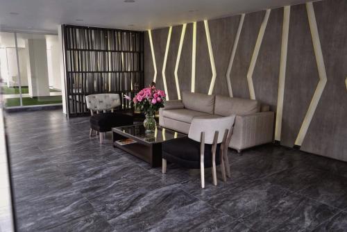 a living room with a couch and a table and chairs at Modern Apartment in the Heart of Quito in Quito