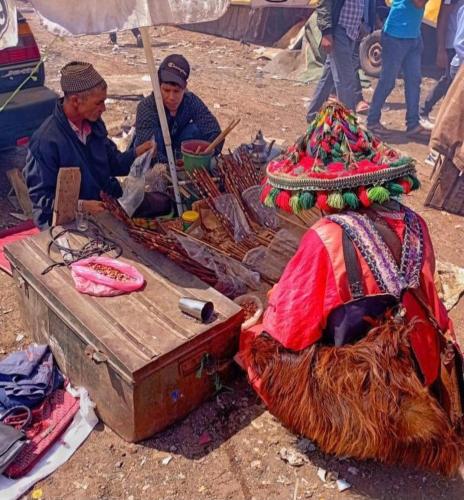 two people sitting under an umbrella at a market at Gest housse ketama 