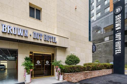 um edifício com uma placa de hotel para cães em frente em Gwangju Brown Dot Cheomdan em Gwangju