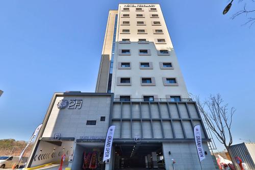 a tall white building with a sign in front of it at Daegu February Hotel Lions Park in Daegu
