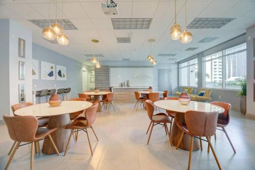 a dining room with tables and chairs and windows at Superb unit, centrally located with parking in Miami