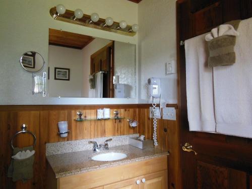 ein Badezimmer mit einem Waschbecken und einem großen Spiegel in der Unterkunft Blue Grouse Country Inn B&B in Clearwater