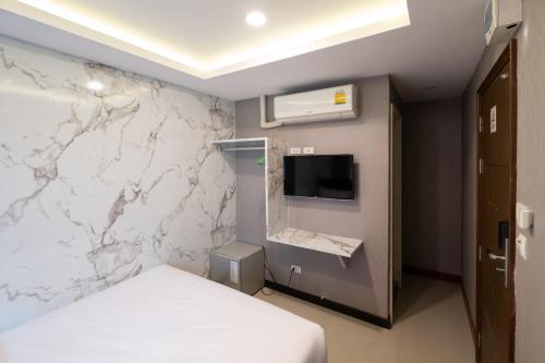 a hotel room with a bed and a wall with marble at Amber Inn in Bangkok