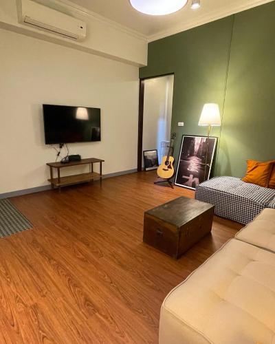 a living room with a couch and a flat screen tv at 本氣宿泊Honkiya in Hengchun