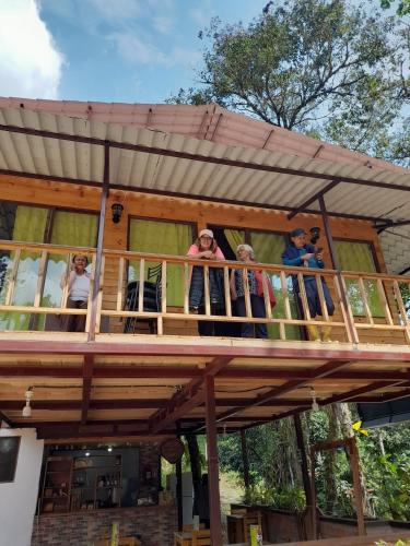 a group of people standing on the balcony of a house at Sendero de las aves in Mindo