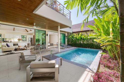 przestrzeń życiowa na świeżym powietrzu z basenem i domem w obiekcie Laem Ka Residence by Tropiclook w mieście Rawai Beach