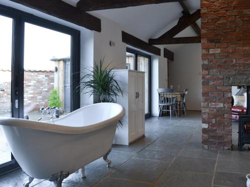 a bath tub in a room with a large window at Sunset Barn - Uk12855 in Normanby