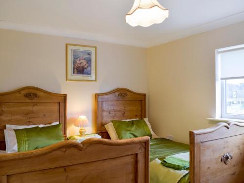 a bedroom with two beds and a window at Moorings House in Fritton Norfolk