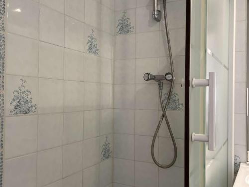 une douche avec pommeau de douche dans une salle de bain dans l'établissement Pavillon calme à Narbonne Plage, 6 couchages, grande terrasse, piscine et parking privé - FR-1-229B-67, à Narbonne