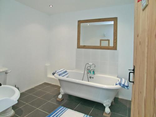a bathroom with a tub and a toilet and a mirror at Proper Job in Tresmeer