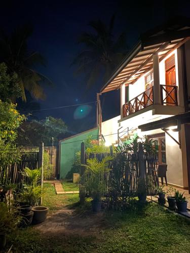 a house at night with a fence and plants at Surf Nest Hiriketiya in Dickwella