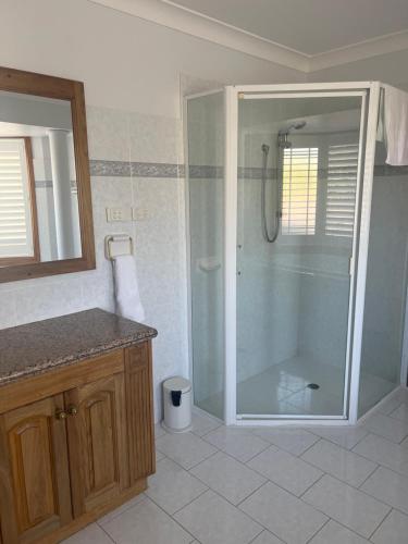 a bathroom with a shower with a glass shower backdoor at Kiama Guesthouse in Kiama