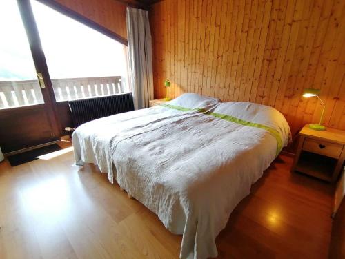 a bedroom with a bed with a large window at Appartement Le Grand-Bornand, 4 pièces, 6 personnes - FR-1-241-63 in Le Grand-Bornand