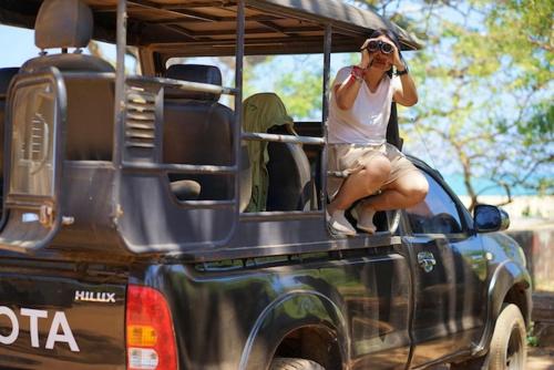 a person sitting in the back of a truck taking a picture at Green Lake in Tissamaharama