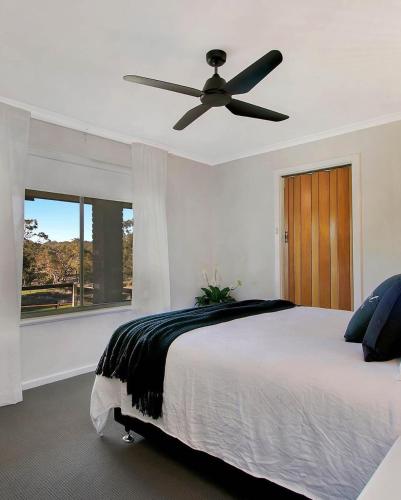 1 dormitorio con 1 cama y ventilador de techo en Gundaroo Retreat, en Cromer