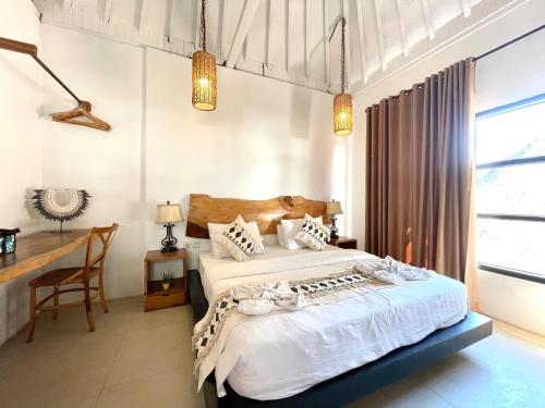 1 dormitorio con 2 camas y escritorio en Gili Breeze Tropical Bungalows, en Gili Trawangan