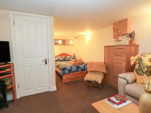 a bedroom with a bed and a couch and a chair at The Shavings in Buxton