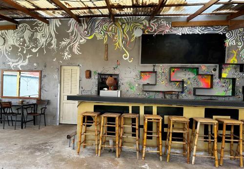 a bar with stools and a screen on the wall at Ginger Sihanoukville in Sihanoukville