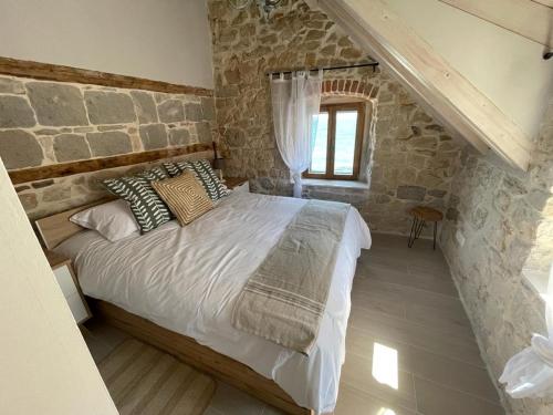um quarto com uma cama numa parede de pedra em Knez apartments and rooms em Kaštela