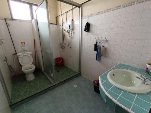 a bathroom with a shower and a toilet and a sink at Mountain View Guest House KB in Kota Belud