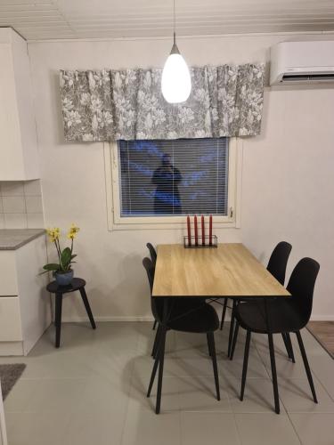 ein Esszimmer mit einem Tisch, Stühlen und einem Fenster in der Unterkunft Home nest in Seinäjoki