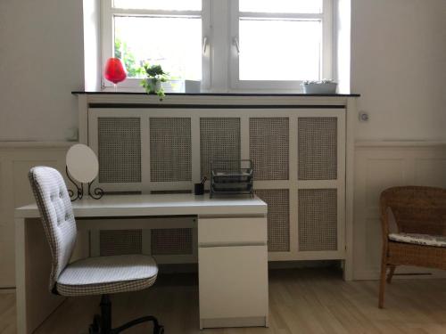 een wit bureau met een raam en 2 stoelen bij East-Village-No 5 Bremen-Sonnenanker in Bremen