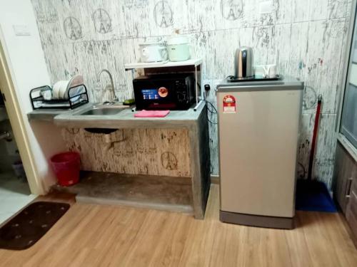 eine kleine Küche mit Spüle und Kühlschrank in der Unterkunft Saville Cheras Studio Next To Mrt Sri Raya Station in Cheras