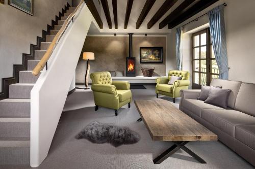 uma sala de estar com uma escada e um sofá e cadeiras em Statek Blatiny em Sněžné