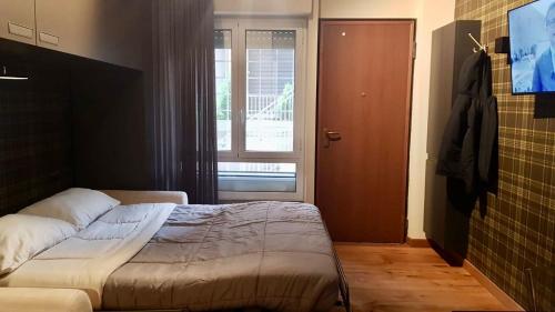 Schlafzimmer mit einem Bett, einem Fenster und einer Tür in der Unterkunft My Home in Parioli in Rom