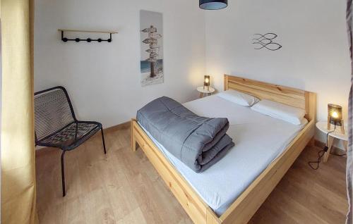 ein kleines Schlafzimmer mit einem Bett und einem Stuhl in der Unterkunft Awesome Home In Les Sables Dolonne With Kitchen in Les Sables-dʼOlonne