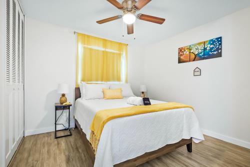 a bedroom with a bed and a ceiling fan at Ixora6 Heated pool mins to beach airport USSSA in Melbourne