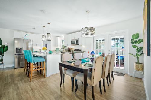 a kitchen and dining room with a table and chairs at Ixora6 Heated pool mins to beach airport USSSA in Melbourne