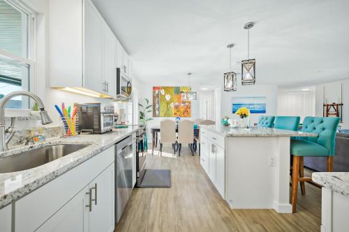 a kitchen with white cabinets and blue chairs at Ixora6 Heated pool mins to beach airport USSSA in Melbourne