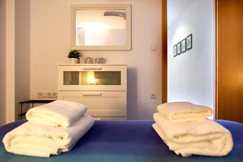 two stacks of towels sitting on top of a bed at Apartamento a 50 metros de la playa, Luminoso y acogedor in Oliva