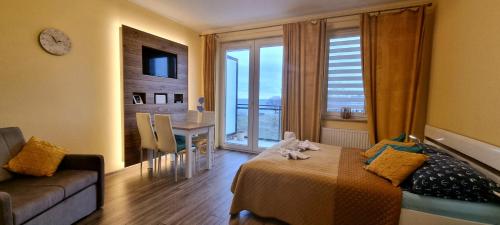 a bedroom with a bed and a couch and a window at Apartament "Złoty relaks" tuż przy plaży z balkonem z widokiem na Hel i hamakami in Puck