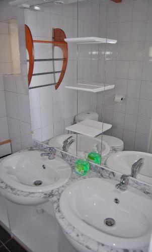 une salle de bain blanche avec deux lavabos et un miroir dans l'établissement Domaine des Hirondelles, à Saint-Vincent-de-Cosse