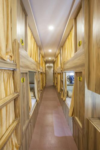 un couloir d'un wagon vide avec des lits superposés dans l'établissement New Abza Dormitory, à Mumbai