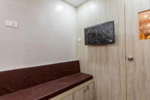 a waiting room with a bench and a painting on the wall at New Abza Dormitory in Mumbai