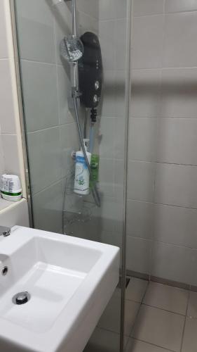a bathroom with a white sink and a shower at SJB Suria Jelutong in Shah Alam