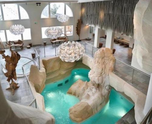 une maison avec une piscine au milieu d'une pièce dans l'établissement LE PLUS BEL APPARTEMENT DES ARCS 1950 SKI/PISCINE, à Bourg-Saint-Maurice
