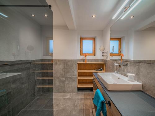ein großes Bad mit einem Waschbecken und einer Dusche in der Unterkunft Appartement Andrea Cäciel in Brixen im Thale