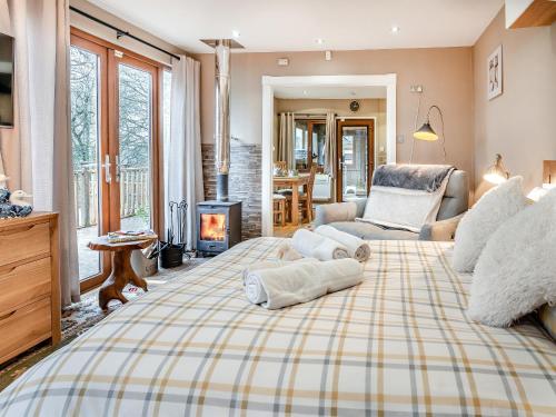 a large bedroom with a large bed with a fireplace at Goshawk Lodge in Abercarn