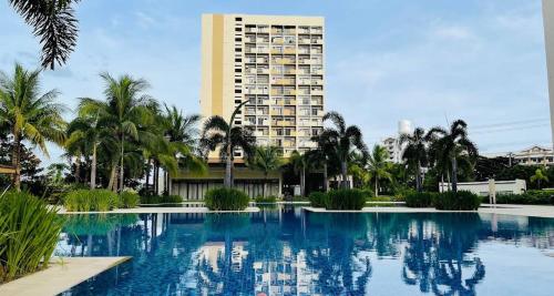 a large swimming pool with a tall building in the background at Alabang Condominium PHC in Manila