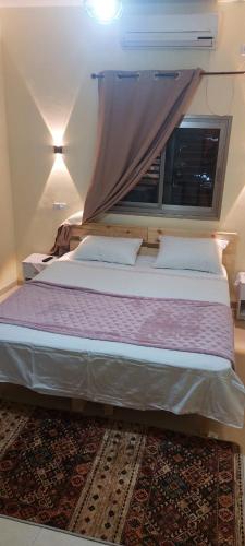 a large bed in a room with a window at Seedi Yousef Hostel & Cafe in Nazareth