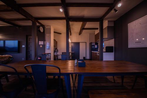a dining room with a wooden table and chairs at Yadoya YADOKARI in Pippu