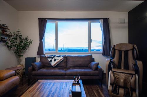 a living room with a couch and a large window at Yadoya YADOKARI in Pippu